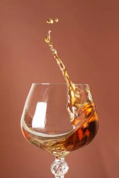 Splash of brandy in glass. Stock Photos