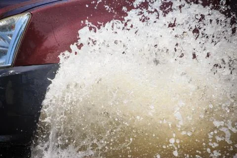 Splash by a car as it goes through flood water 스톡 사진