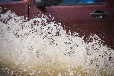 Splash by a car as it goes through flood water 스톡 사진