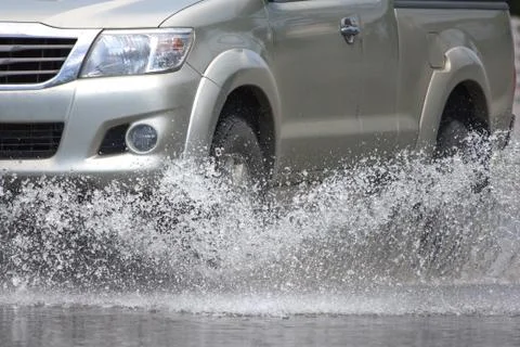 Splash by a car as it goes through flood water 스톡 사진