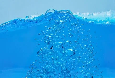Splash of clear blue water with bubbles and ripples Stock-Fotos