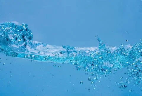 Splash of clear blue water with bubbles and ripples Stock-Fotos
