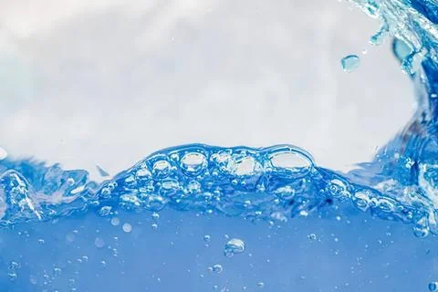 Splash of clear blue water with bubbles and waves Stock Photos