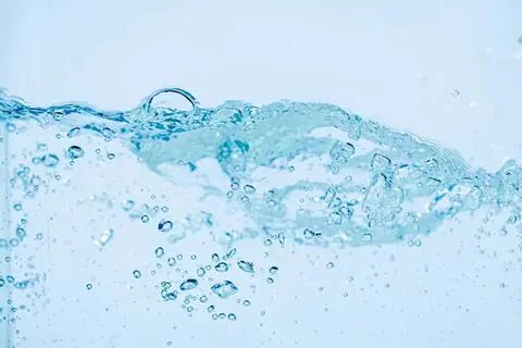 Splash of clear blue water with bubbles and waves Stock Photos