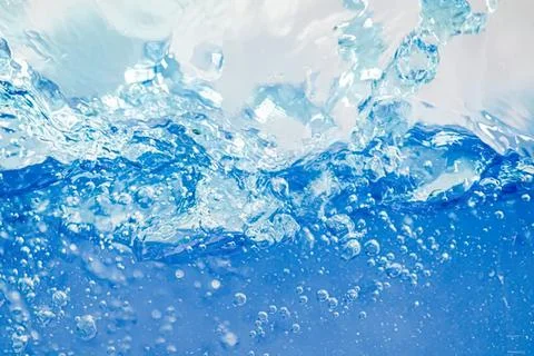 Splash of clear blue water with bubbles and waves Stock Photos