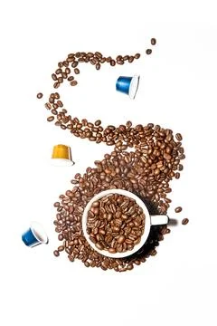 Splash of coffee beans from a white cup full of fresh dark roasted coffee beans Stock Photos