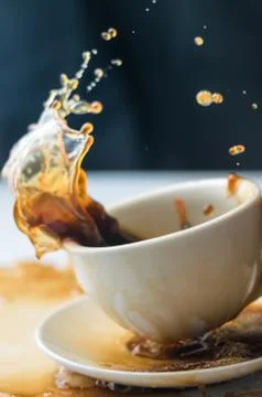 Splash of coffee in white cup Stock Photos