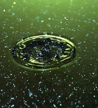 Splash - a drop falling onto the water surface in a color macro shot Stock Photos