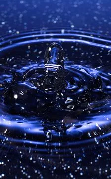 Splash - a drop falling onto the water surface in a color macro shot Foto stock