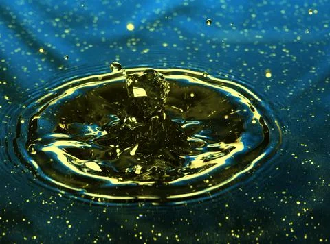 Splash - a drop falling onto the water surface in a color macro shot Stock Photos