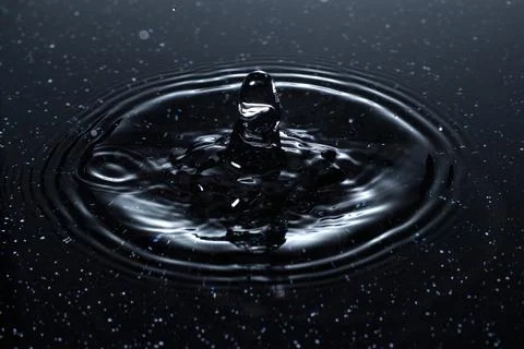 Splash - a drop falling onto the water surface in a color macro shot Foto stock