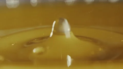 Splash from the fall of jet of golden sunflower or motor car oil in slow motion Stock Footage 309952004