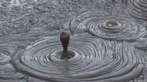 Splash of a geothermal discharge in a mud pool Stock Photos