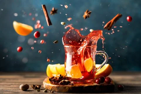 A splash of hot mulled wine with oranges, cranberries and spices in a glass. Stock Photos