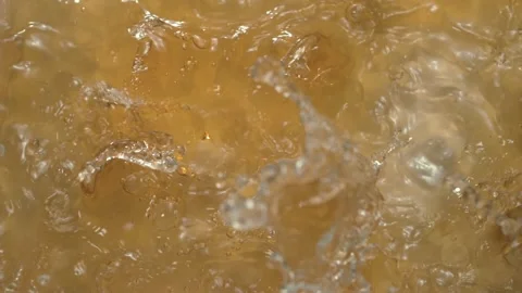 Splash of liquid texture with a yellowish tint. Stock Footage 268743932