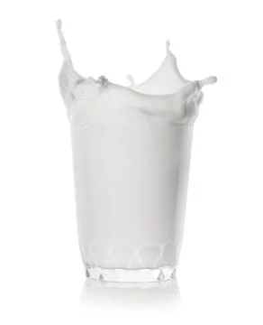 Splash in a low glass of milk Stock Photos