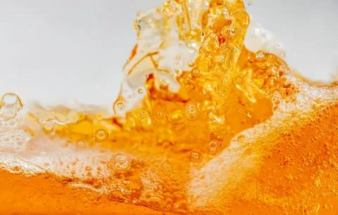 Splash of orange juice with bubbles and foam Stock Photos