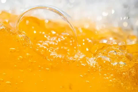 Splash of orange juice with bubbles and glass Stock Photos