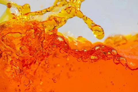 Splash of orange liquid with bubbles and motion Stock Photos