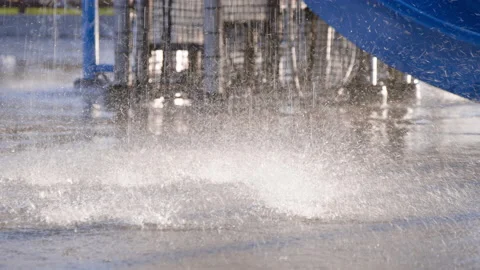 Splash pad water splashes on the ground in slow motion, summer sunset Stock Footage 233944725