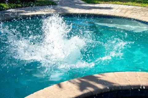 A Splash in a Pool Caused By a Boy Jumping Into the Water Stock Photos
