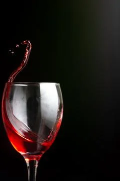 Splash of red wine on a black background Stock Photos