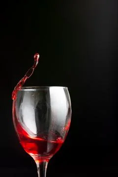 A splash of red wine in a stemware drinkware glass Stock Photos