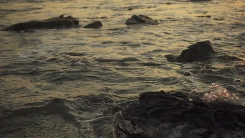 Splash of small waves on the rocks at sunset slow motion Stock Footage 81175757