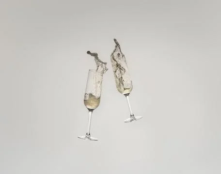 Splash of two crystal glasses toasting with champagne for a celebration. Splash Stock Photos