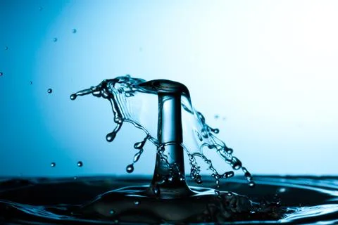 Splash of water on blue background Stock Photos