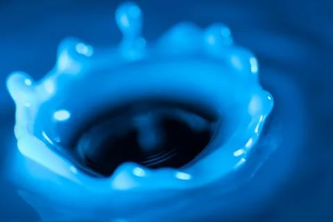 Splash of water crown on blue surface. Stock Photos
