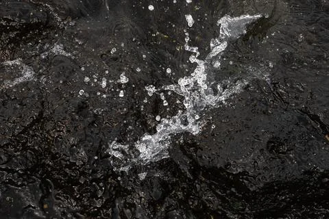 A splash of water on a dark surface Stock Photos