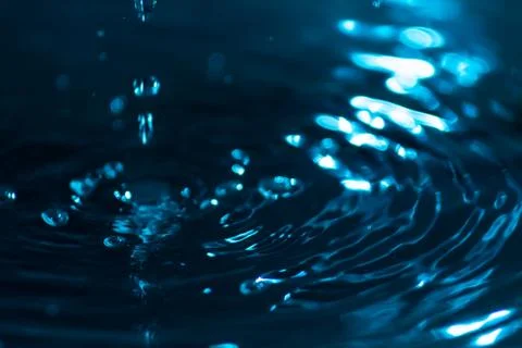 Splash of water drops on a water surface colored with celestial ink. Concept Foto stock