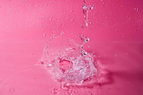 Splash of water on a red background. Abstract wallpaper Stock Photos
