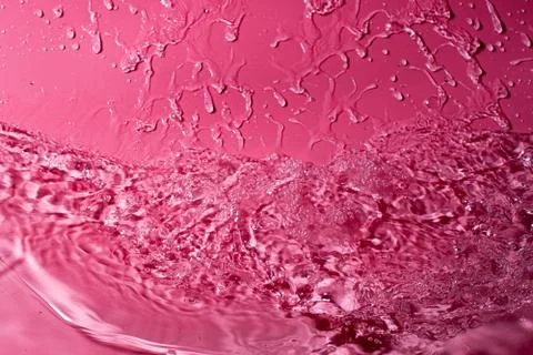 Splash of water on a red background. Abstract wallpaper Stock Photos
