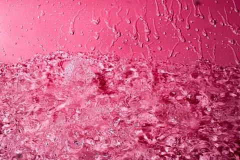 Splash of water on a red background. Abstract wallpaper Stock Photos