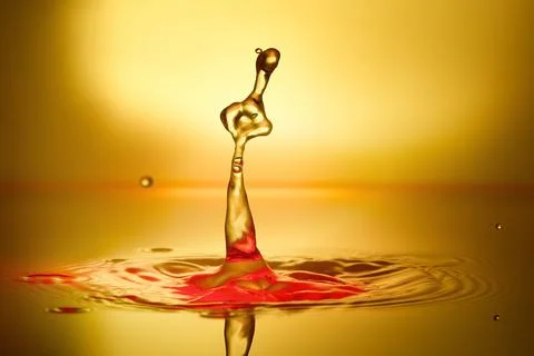 Splash of water on a yellow background Stock Photos