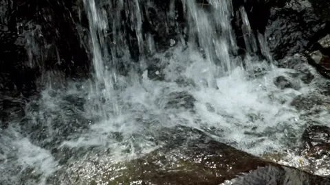 Splash of waterfall falling on river rocks Stock Footage 320104854
