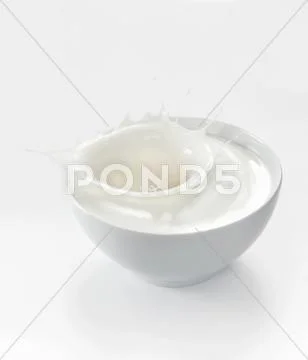 A splash of yogurt in a white bowl Stock Photos