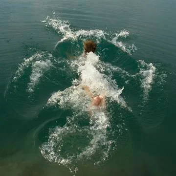 Splashes after jumping into the water Stock Photos