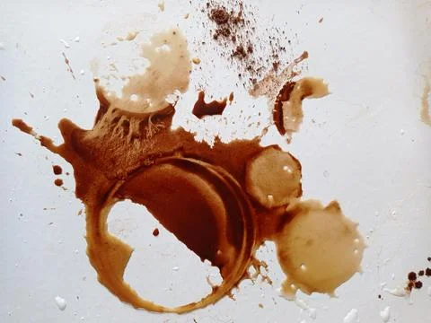 Splashes and drops of spilled coffee on white table Stock Photos