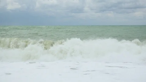 Splashes and foam from the wave rolling on the shore Video stock 82313701