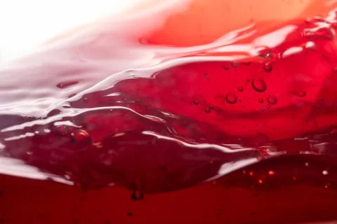 Splashes, bubbles and waves from red wine in a glass, macro Stock Photos