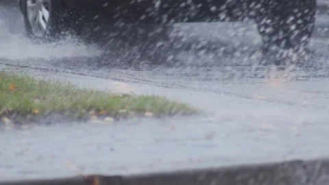 Splashes from car wheels on the road while driving through puddles in the city Stock Footage 303138903