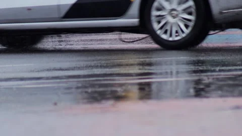 Splashes from car wheels on the road while driving through puddles in the city Stock Footage 303139231