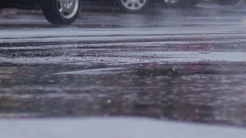 Splashes from car wheels on the road while driving through puddles in the city Stock Footage 303139498