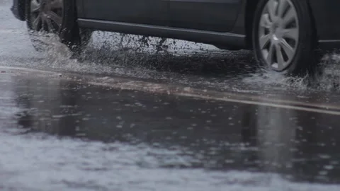 Splashes from car wheels on the road while driving through puddles in the city Video stock 311645378