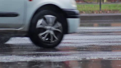 Splashes from car wheels on the road while driving through puddles in the city Stock Footage 312595070