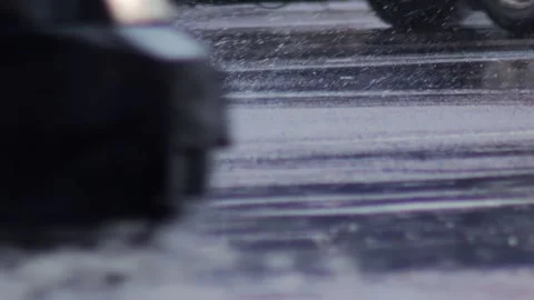 Splashes from car wheels on the road while driving through puddles in the city Stockbeeldmateriaal 313890872