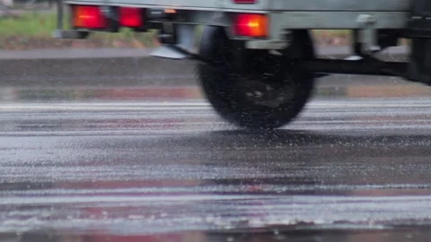 Splashes from car wheels on the road while driving through puddles in the city Stock Footage 313891172